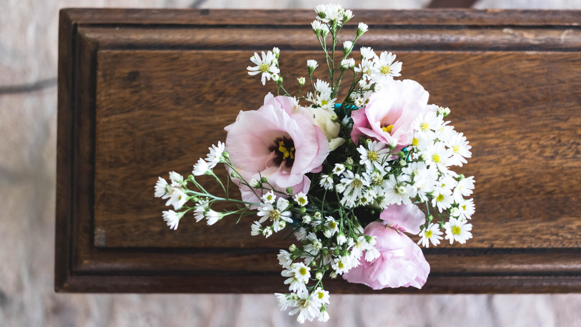 Flowers on a casket, representing the loss of a loved one