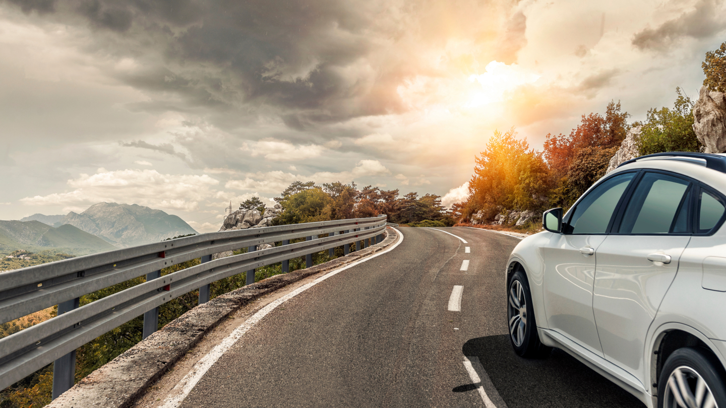 A car on a winding California road, travelling to meet clients